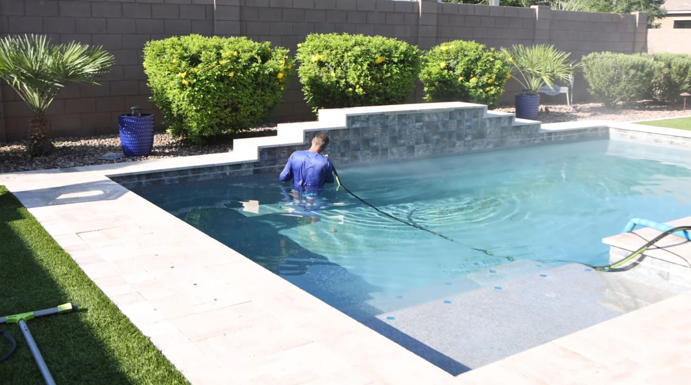 Pool technician performing deep pool cleaning service in Hawthorne, CA